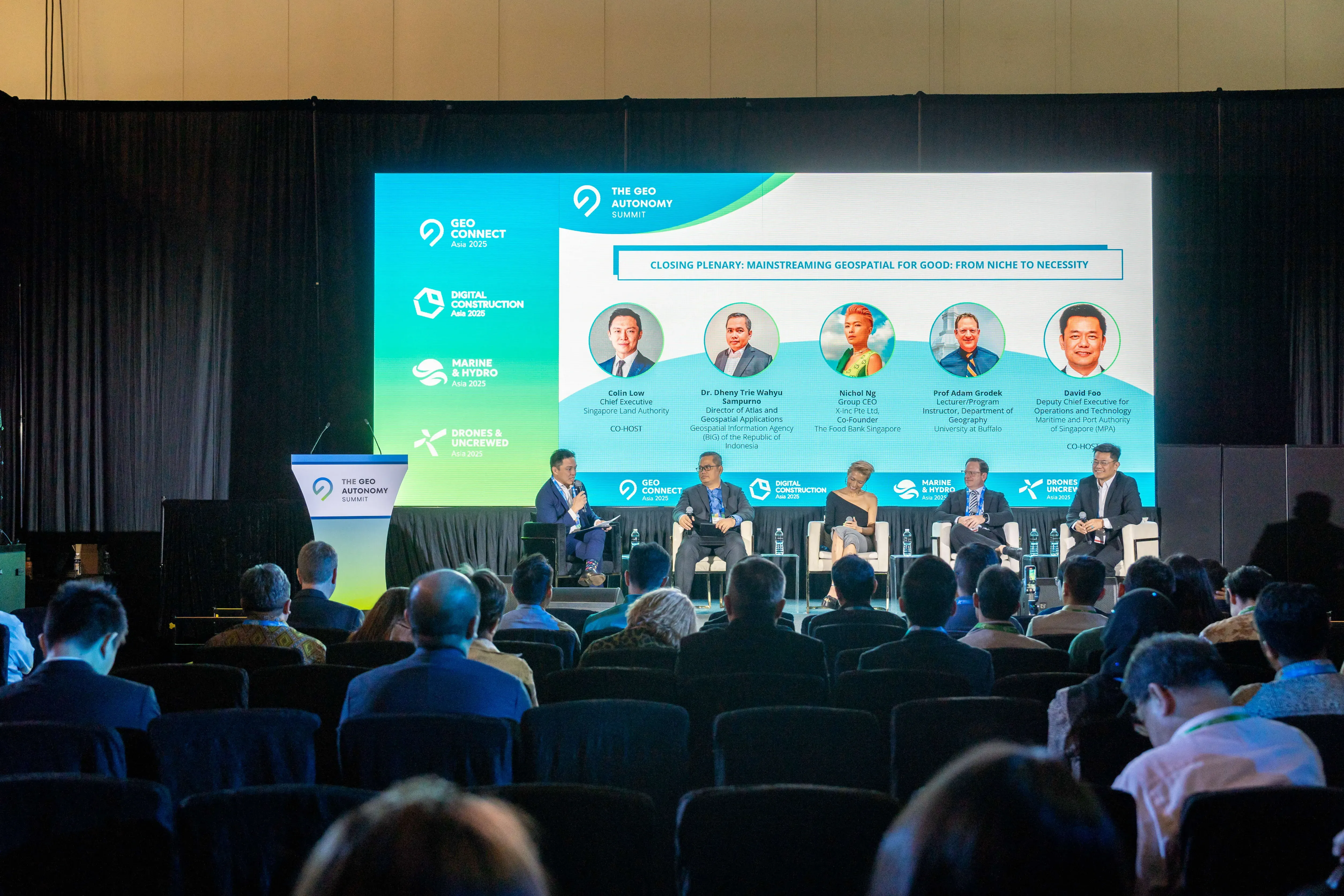 Five panelists seated on stage at the Geo Autonomy Summit closing plenary, with an audience watching from rows of chairs.